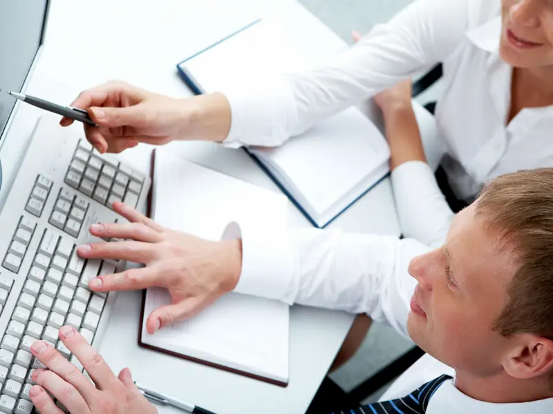 Shared Services: El secreto de las empresas eficientes para reducir costos y escalar operaciones 1 - GSG Consultores Profesionales analizando información en computador durante asesoría corporativa con GSG Consultores